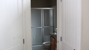A bathroom with a shower, toilet, and sink.