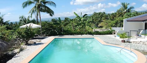 Una piscina al aire libre, sillones reclinables de piscina