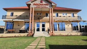 A two-story building with a sign reading "PARIS HOTEL" and a balcony on the upper floor. - Parigha Hotel (Accra)