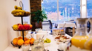 A breakfast buffet with various fruits, pastries, and beverages. - Hotel Garni Reis (Treis-Karden)