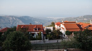 A residential area with houses featuring red-tiled roofs, surrounded by greenery and hills in the background. - Traditional Luxury Villa Armonia (Aigialeia)