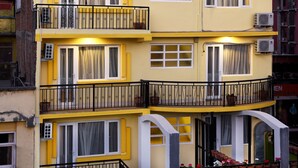 A multi-story building with balconies, air conditioning units, and a visible chimney. - Hotel Ruza Nepal (Kathmandu)