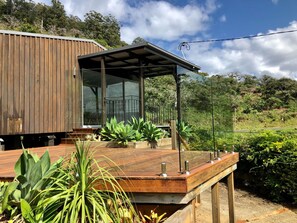 Un bâtiment moderne en bois, doté d’une terrasse couverte et de grandes fenêtres.