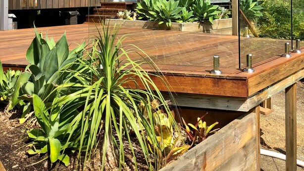 Un bâtiment moderne doté d’une terrasse en bois et d’une structure vitrée.