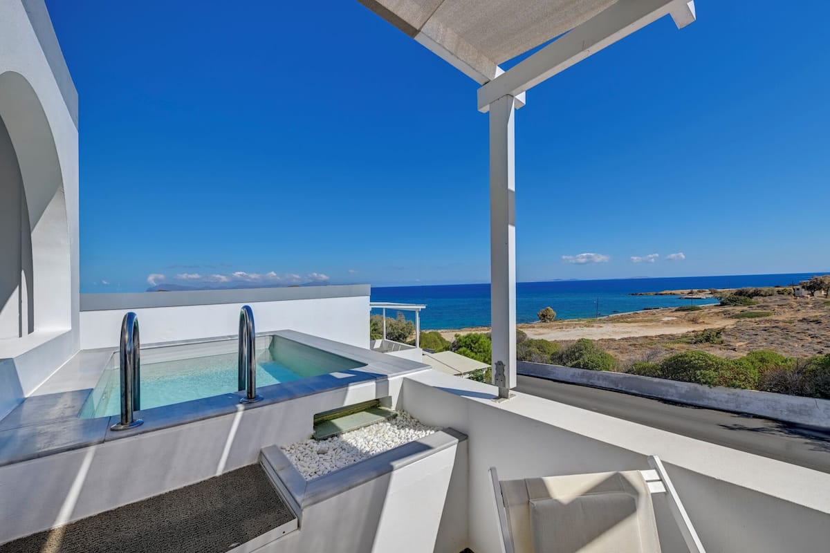 A rooftop terrace with a pool, outdoor seating, and a view of the sea.