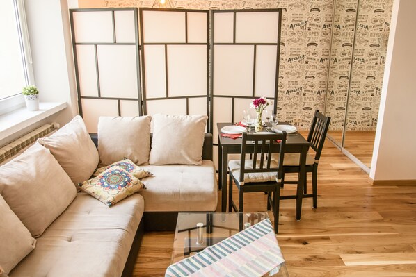 Relax in a stylish living room with a beige sofa, glass coffee table, and dining area.