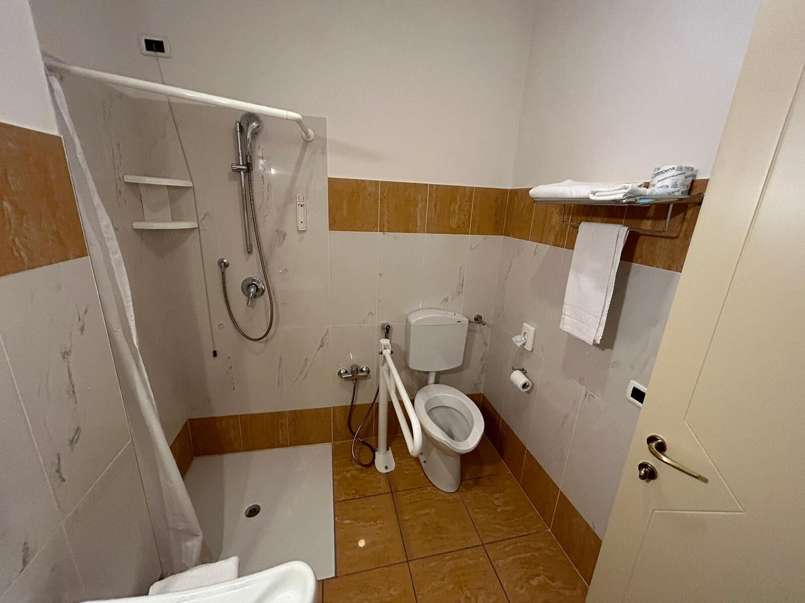 A bathroom with a shower, toilet, and sink.