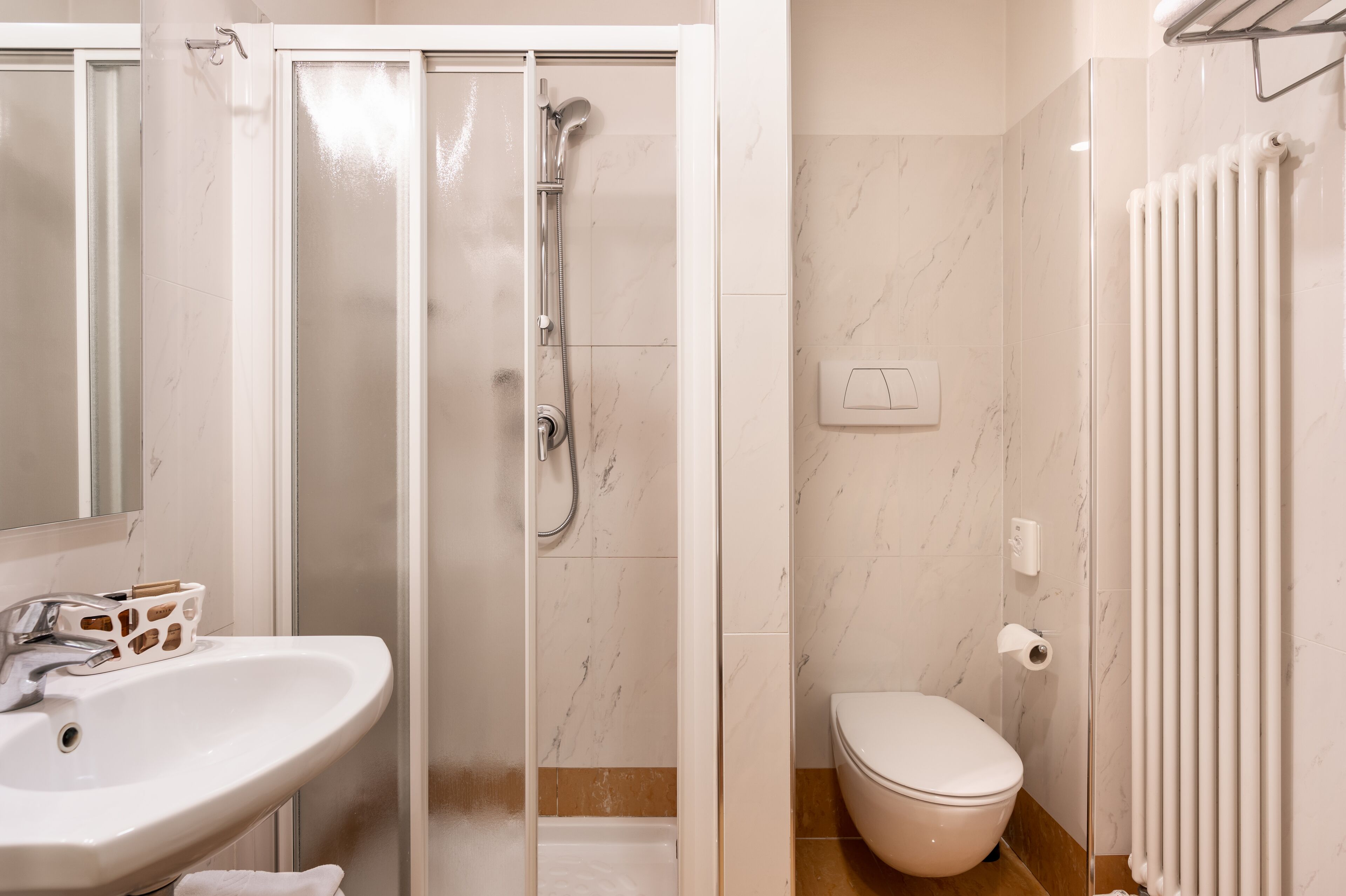Ein Badezimmer mit Dusche, Toilette und Waschbecken.
