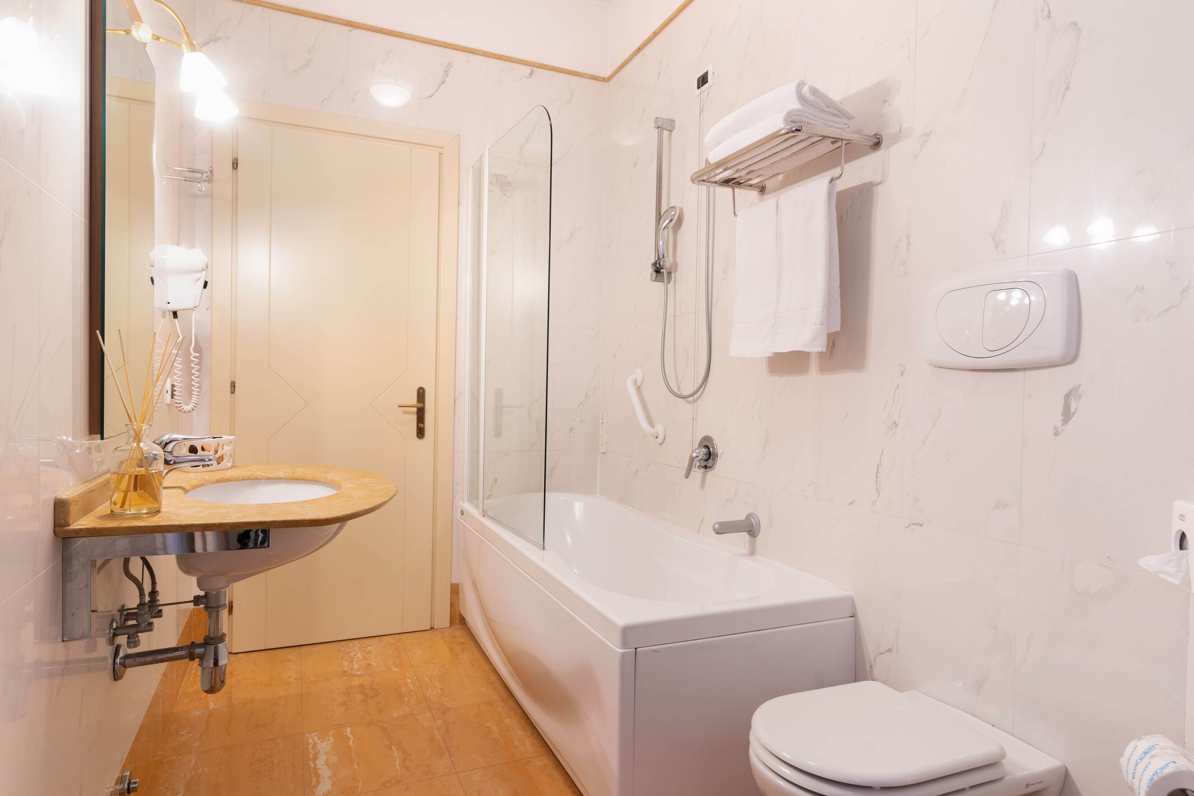 Une salle de bain moderne avec un lavabo, des toilettes et une baignoire.