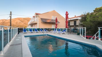 Una piscina al aire libre de temporada, sillones reclinables de piscina