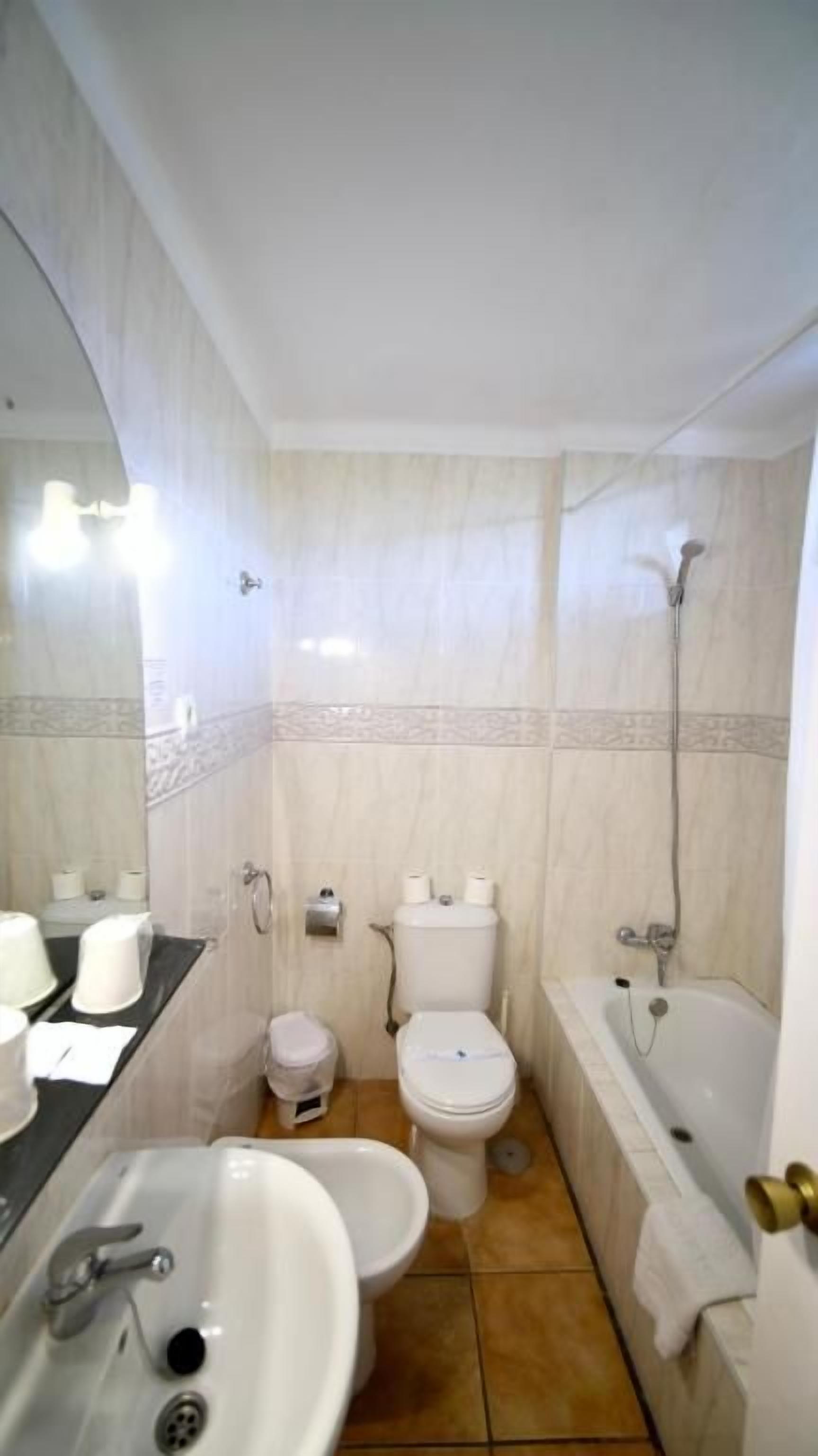 Un baño con lavamanos, inodoro, bidé y bañera.