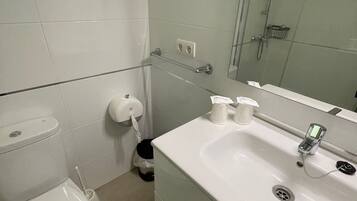 Un baño con inodoro, lavamanos y ducha.