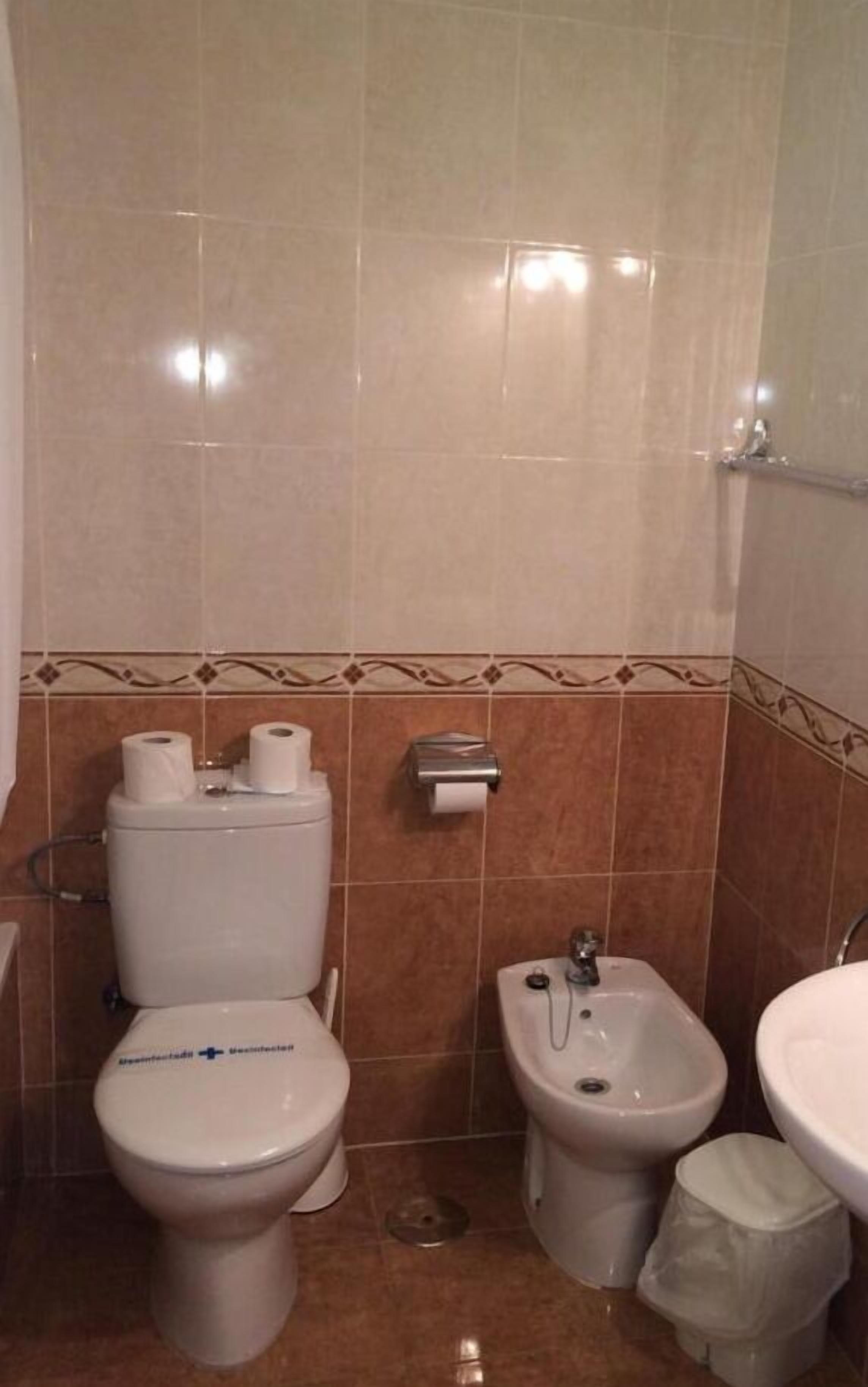 A bathroom with a toilet, bidet, and sink.