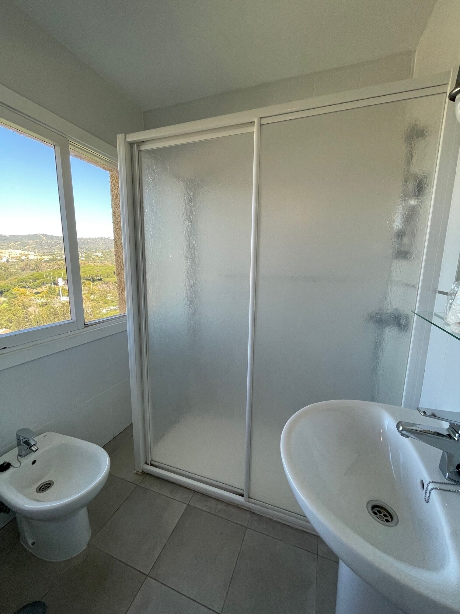 A bathroom with a toilet, bidet, and sink.
