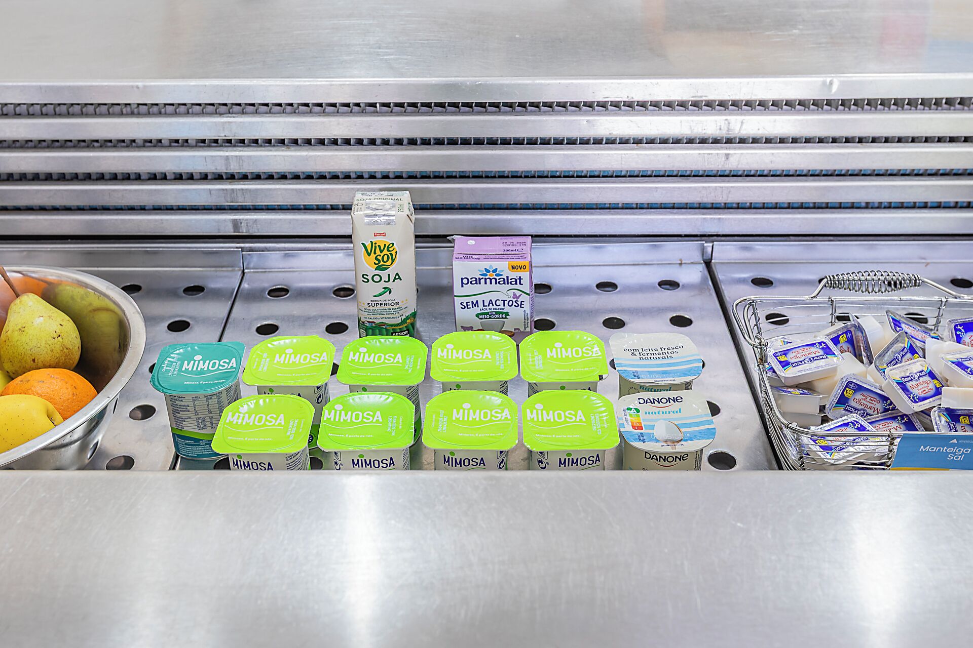 A refrigerated display with various dairy products including Mimosa, Vive Soy, and Panone.