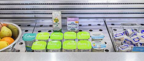 A refrigerated display with various dairy products including Mimosa, Vive Soy, and Panone.