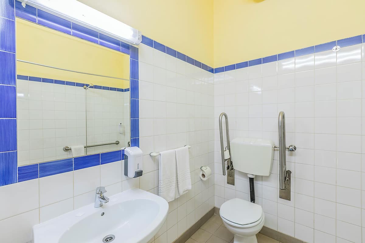 Een badkamer met een wastafel, toilet en spiegel.