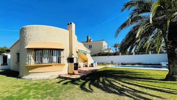 Experience a tranquil retreat with a lawn, pool, and a unique, curved facade.