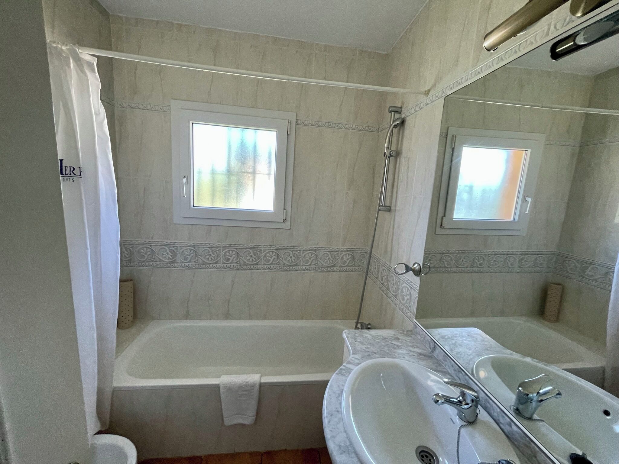 A bathroom with a bathtub, a sink, and a window.