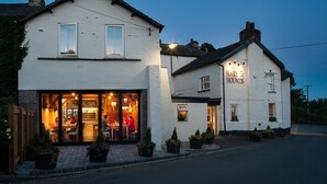 A white building with a sign reading "Hare & Rounds" at the entrance. - Hare & Hounds (Kendal)