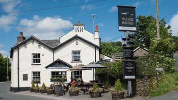 Un edificio blanco con un cartel que dice "Hare & Hounds Inn & Dining" y un cartel que indica "Aparcamiento a 30 yardas a la izquierda".