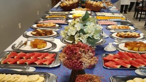 Una mesa de buffet con diversos alimentos y flores decorativas.