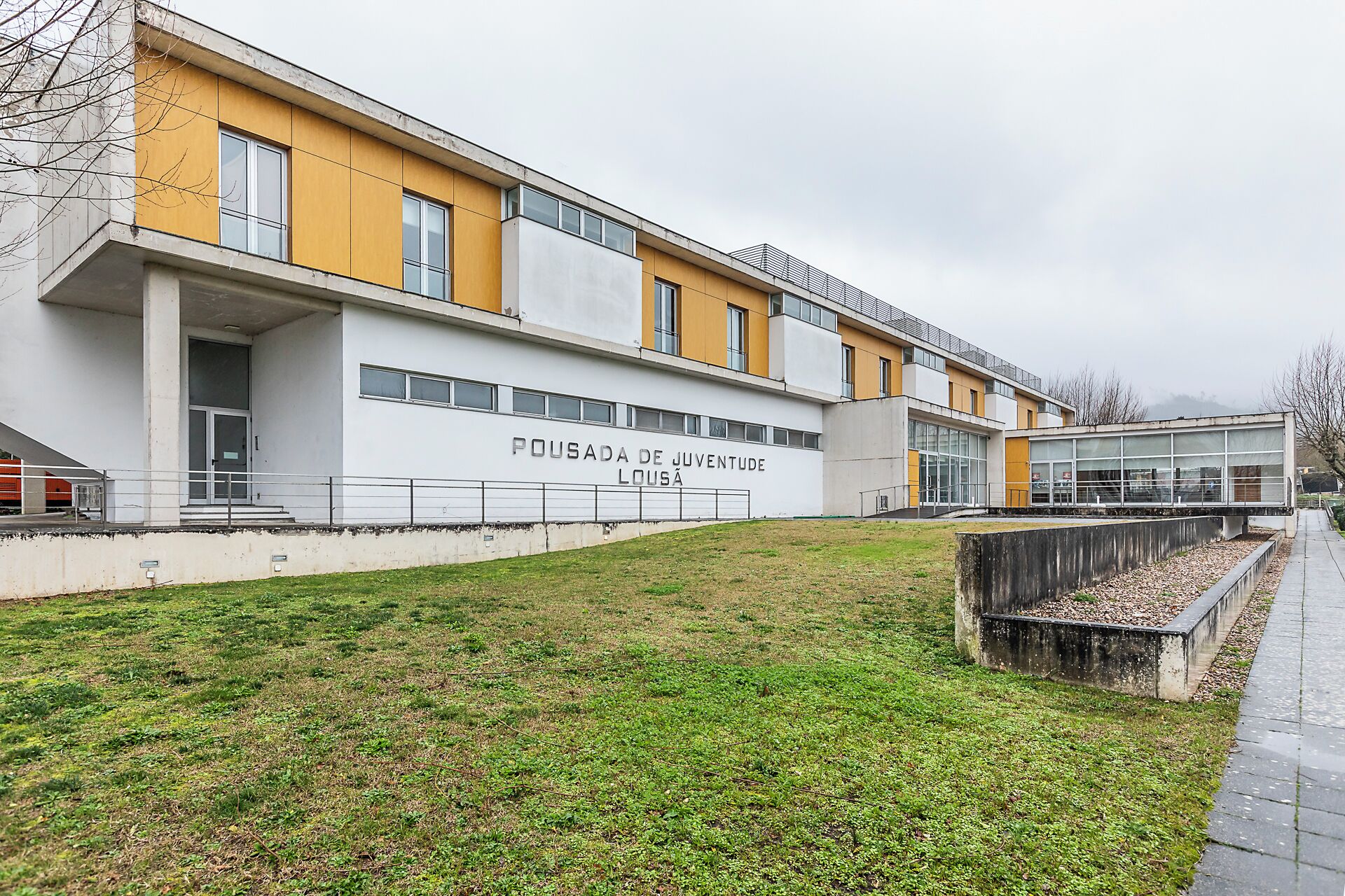 Un edificio moderno con un letrero que dice "POUSADA DE JUVENTUDE LOUSA".