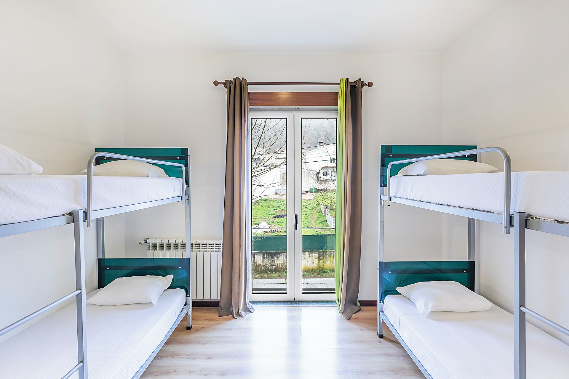 Un dormitorio con literas, un radiador y vistas al exterior.