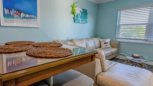 A living room with a glass-top dining table, beige sofa, and a glass coffee table. - Luxury Beach Condo on Manasota Key ! 
650 feet to beach. (Manasota Key)