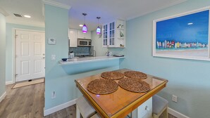 Una cocina moderna con armarios blancos, un microondas y una lámpara colgante.