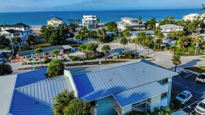Un área residencial costera con casas, una playa y una vista despejada del océano.