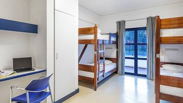 Una stanza del dormitorio con letti a castello, una scrivania con un portatile e una sedia.