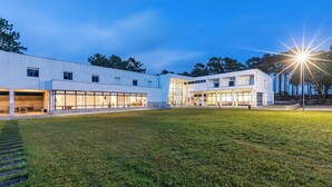 Een modern gebouw met grote ramen en een gazon.