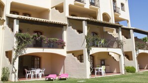 A multi-story hotel with balconies, outdoor seating, and a well-maintained lawn. - Apartamentos El Toro (Marbella)