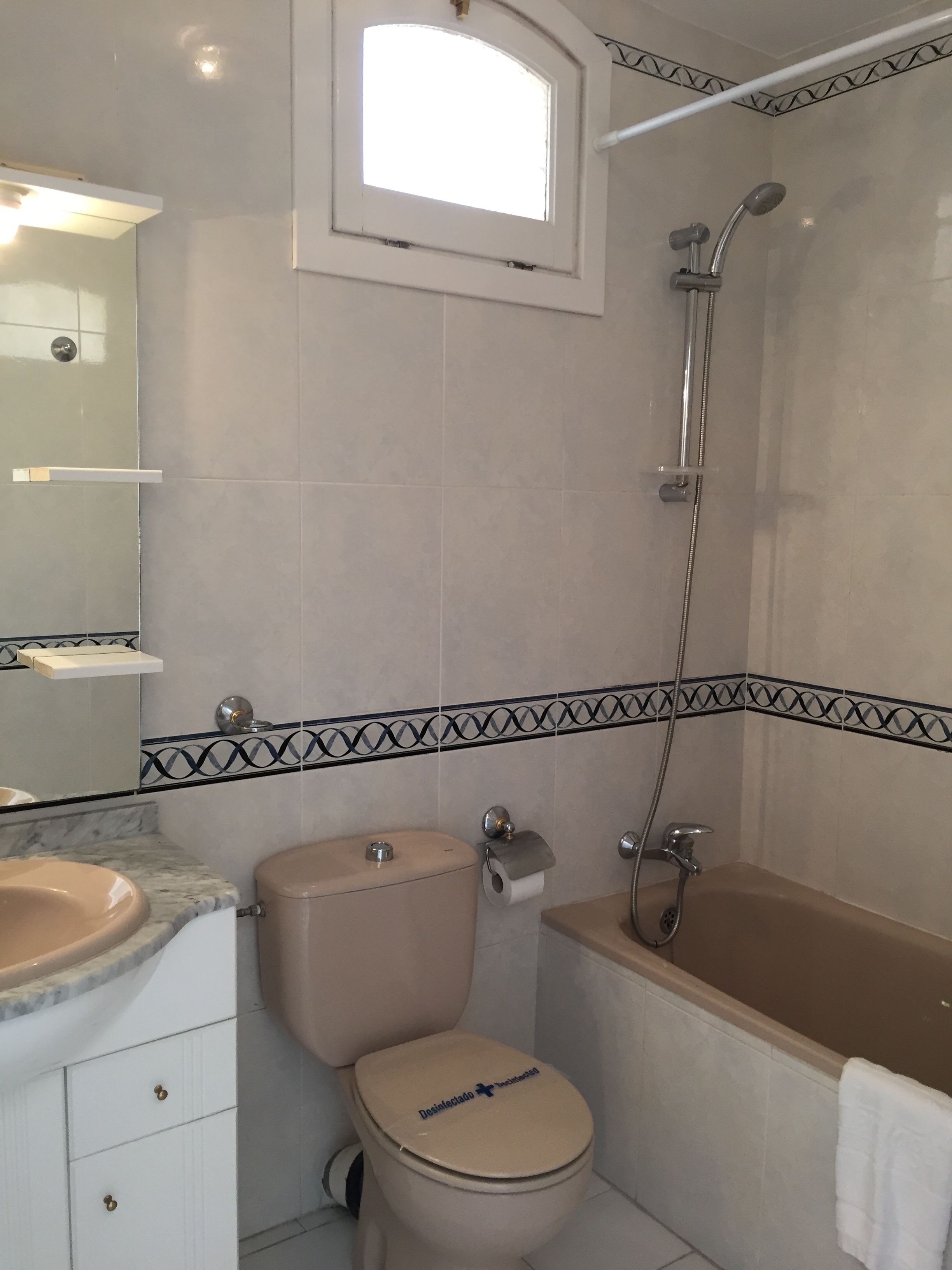 Une salle de bain comprenant des toilettes, un lavabo, une baignoire et une douche.
