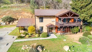 A two-story house with a balcony, a small attached garage, and a well-maintained lawn.