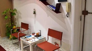 A small, private room with two chairs, a table, and a bookshelf.