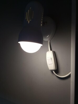 A wall-mounted desk lamp with a switch.