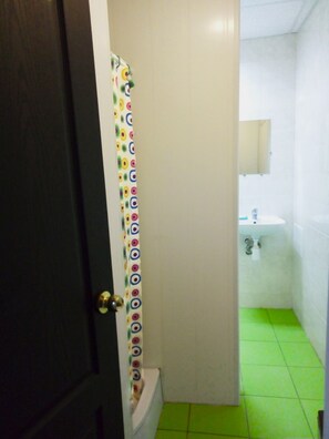 A bathroom with a toilet, a sink, and a mirror.