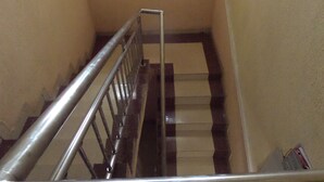 A staircase with a metal handrail and wooden steps. - Fatty K Hotel and Suites (Ota)