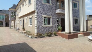 A multi-story residential building with a symmetrical facade, large windows, and a central entrance with a staircase. - Fatty K Hotel and Suites (Ota)