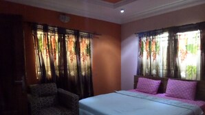 A bedroom with a bed, a chair, and a small table. - Fatty K Hotel and Suites (Ota)