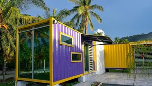 A modern, compact building with large glass windows and a vibrant purple and yellow exterior. - Lumut Cube Homestay Kontena (Lumut)