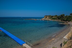 Una playa cerca, sillas reclinables de playa, sombrillas
