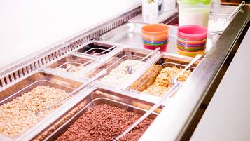 A buffet with various food items in clear containers, including rice, beans, and other grains.