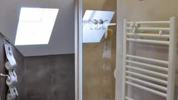 A bathroom with a skylight, a shower, a toilet, and a towel rack.