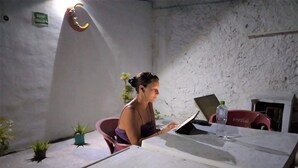A room with a white table, a laptop, a Coca-Cola bottle, and a potted plant. - Hotel Casa Lidia (Mérida)