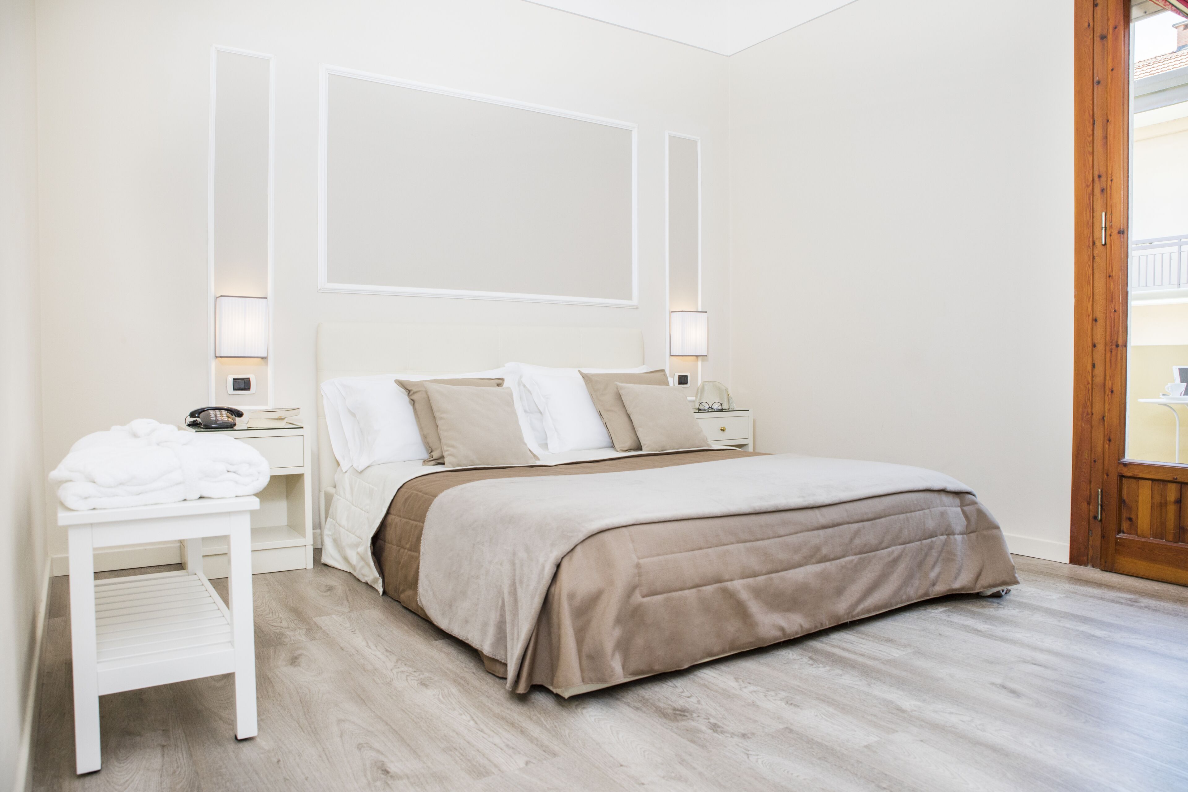Une chambre à coucher avec un lit, des tables de chevet et une commode.