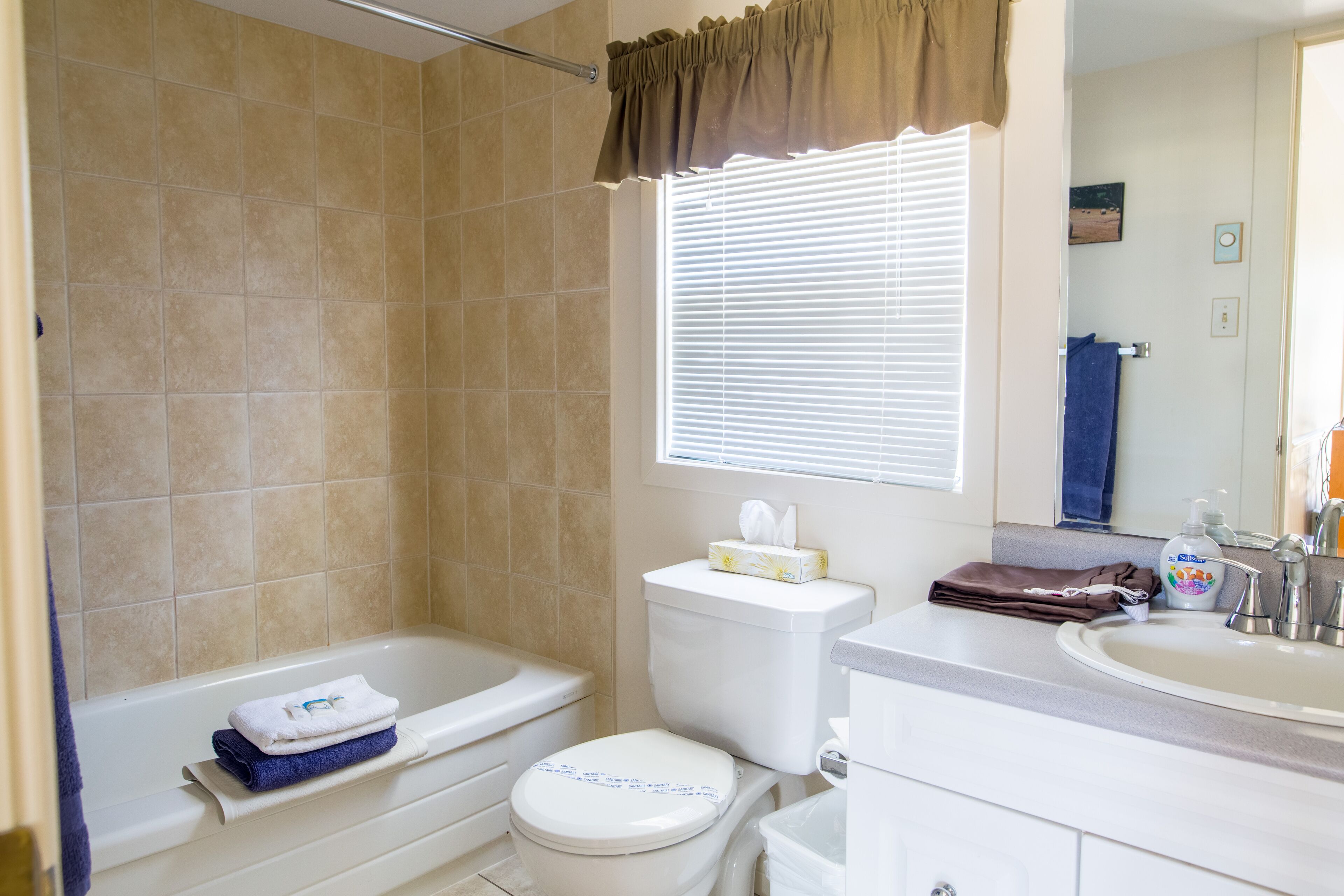 A bathroom with a bathtub, toilet, and sink.
