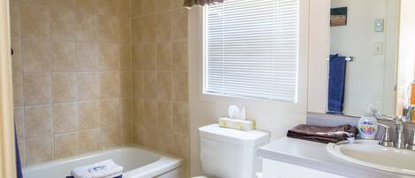 A bathroom with a bathtub, toilet, and sink.
